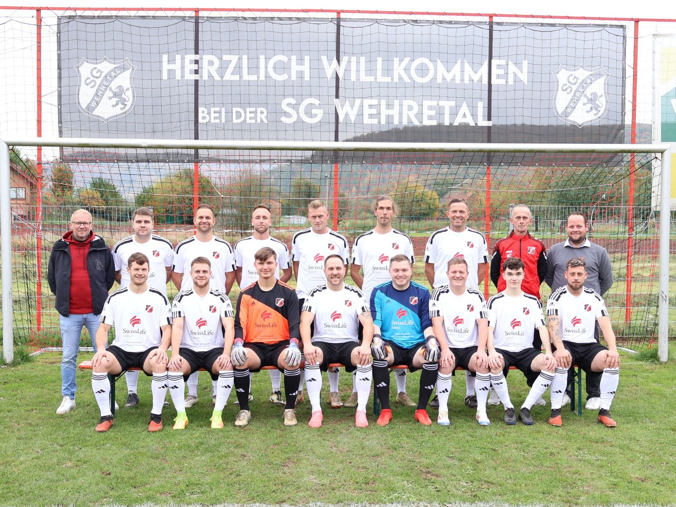 SGW-Mannschaft in weißen Trikots vor einem Tor mit Vereinsbanner